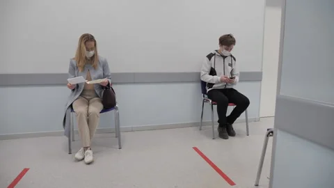 Patients wait in line and keep their distance from each other Stock-Footage 131460818