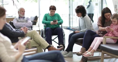 Patients waiting to be called in a crowded hospital waiting room Stock Footage
