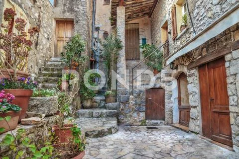 Patio with flowers in the old village France Stock Photos