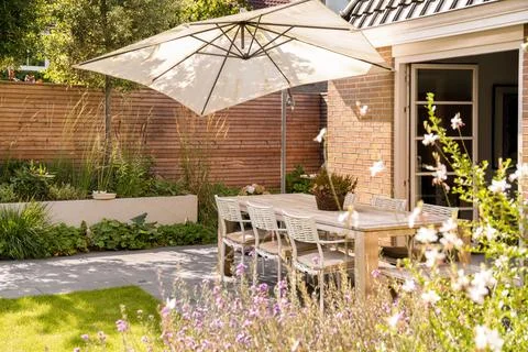 A patio with a table and chairs under an umbrella Stock Photos