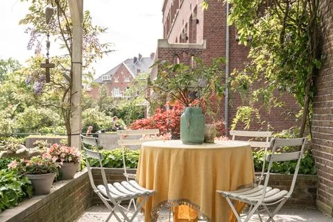 A patio with a table with a vase on Stock Photos