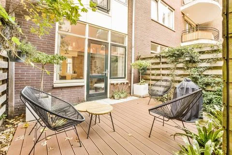 A patio with two chairs and a table on a Stock Photos