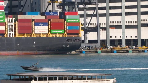 Patrol boat speeding past container cargo ship at Hong Kong port Stock Footage 345986422