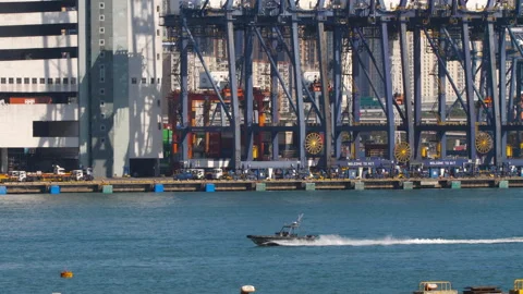 Patrol speedboat passing container terminal and cargo ship in Hong Kong Stock Footage 346352009