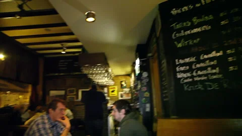 Patrons Drinking at Counter to Blackboard Menu Interior Panning Shot 스톡 동영상 346823031