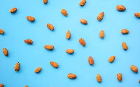 Pattern of almonds nuts arrange on blue background Stock Photos