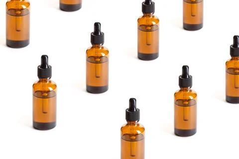 Pattern of Amber Bottles with dropper on white background Pattern of Amber... Stock Photos