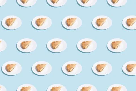 Pattern of apple pie slices on white plate on blue background. trendy food Stock Photos