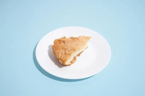 Pattern of apple pie slices on white plate on blue background. trendy food Stock Photos