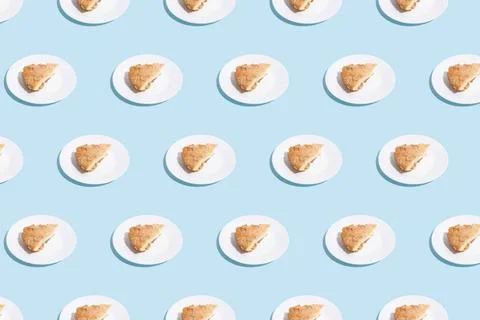 Pattern of apple pie slices on white plate on blue background. trendy food... Stock Photos