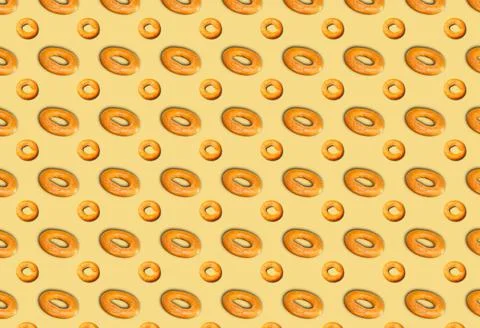 A pattern of bagels on a beige background. Bakery template. 스톡 사진