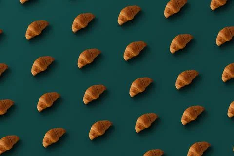 Pattern of baked croissants with a turquoise background. Delicious pastries Stock Photos