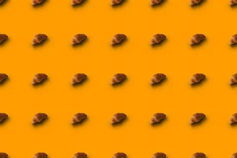 Pattern of baked croissants with a yellow background. Delicious pastries Stock Photos