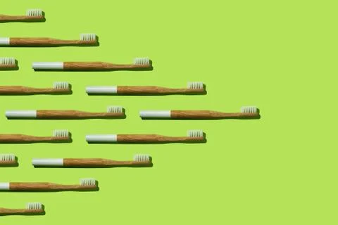 Pattern: bamboo toothbrushes wedge-shaped on green background Stock Photos