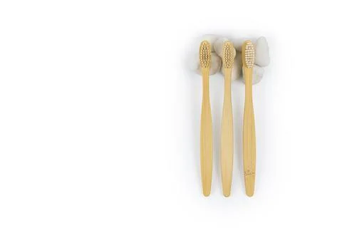 Pattern from bamboo toothbrushes with white stones on a white background. Stock-Fotos