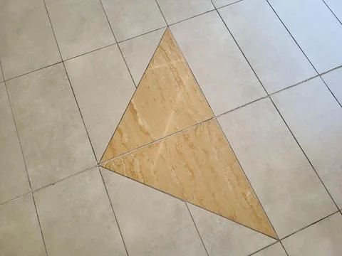 A pattern of beige and grey glossy floor tiles. Stock Photos