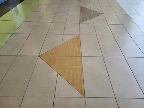 A pattern of beige and grey glossy floor tiles 스톡 사진