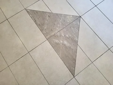 A pattern of beige and grey glossy floor tiles. Stockfoto's