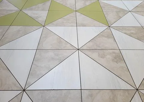 A pattern of beige and grey glossy floor tiles. Stock Photos