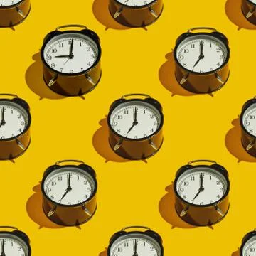 Pattern Black alarm clock with a hard shadow on a yellow background Stock Photos