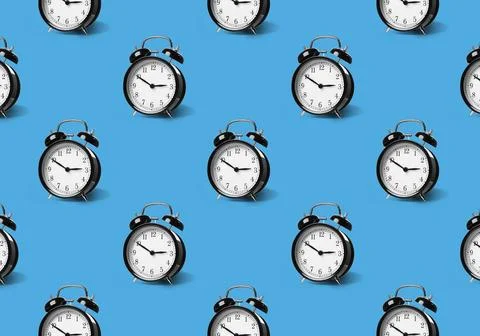 Pattern of black alarm clocks on pale blue background 스톡 사진