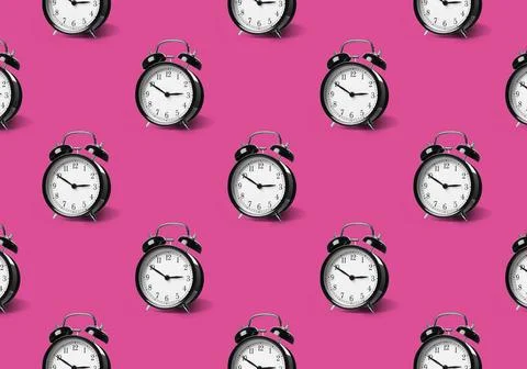 Pattern of black alarm clocks on violet red background Foto stock