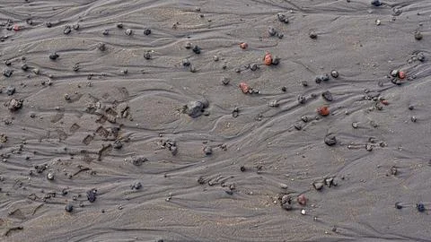 Pattern of black flickering volcanic sand texture. Volcano Foto stock