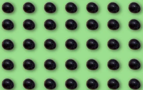 Pattern with black grapes with shadow on a green background. Foto stock