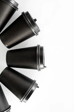 Pattern of black paper cups for tea or coffee on a white background. Recyclin Stock Photos