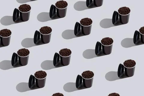 Pattern black paper disposable cups with coffee beans on white background Stock Photos