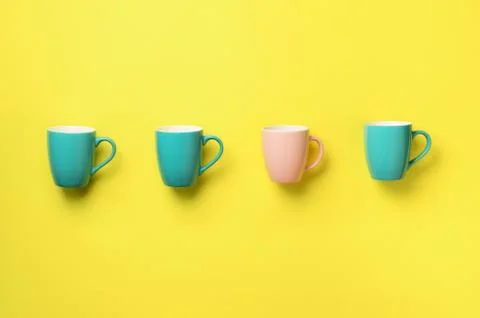 Pattern from blue and pink cups over yellow background. Birthday party Stock Photos