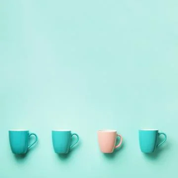 Pattern from blue and pink cups over turquoise background. Square crop. Birthday Stock Photos