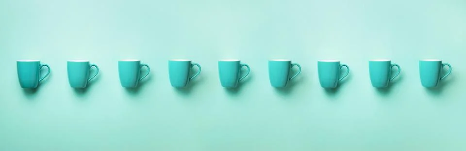 Pattern from blue cups over blue background. Banner. Birthday party celebration Stock Photos