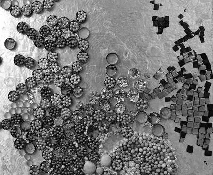 A pattern of bottle caps filled with beads and more Stock Photos