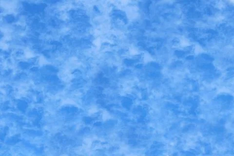 Pattern, bright blue sky with delicate clouds as a background. Stock Photos