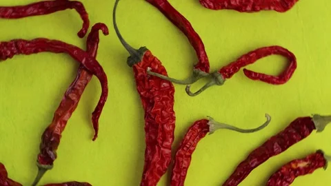 A pattern of bright red dry hot peppers on a bright yellow cloth, top view, c Video stock 171658699