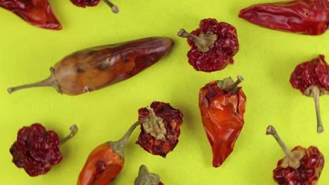 A pattern of bright red dry hot peppers on a bright yellow cloth, top view, c Video stock 179553809