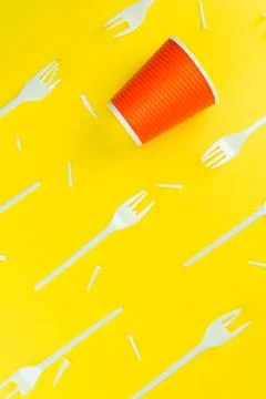 Pattern of broken plastic forks, and plastic cup on a yellow background. Stock Photos