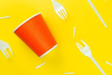 Pattern of broken plastic forks, and plastic cup on a yellow background. Stock Photos