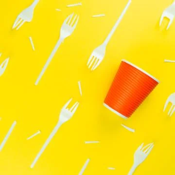 Pattern of broken plastic forks, and plastic cup on a yellow background. Stock Photos