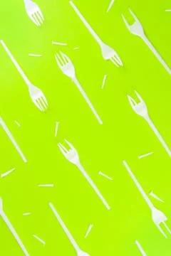 Pattern of broken plastic forks on a green background. Stock Photos
