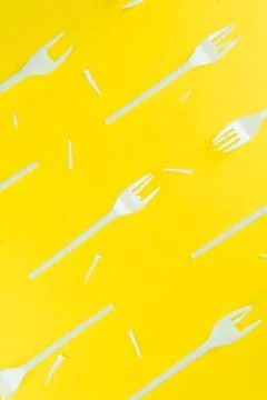Pattern of broken plastic forks on a yellow background. Stock Photos