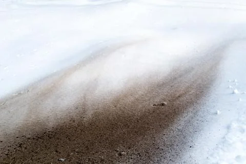 Pattern of brown dust and dirt on pure white snow Stock Photos