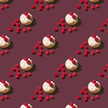 Pattern of a bun with powdered sugar and raspberries on a dark red background Stock Photos