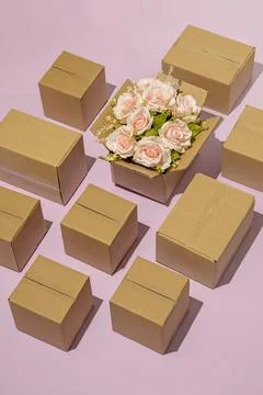 Pattern cardboard box delivery logistics blooming bouquet of pink roses as a  Stock-Fotos