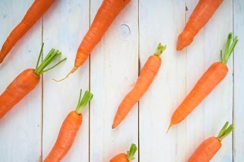 Pattern of carrots. Top view of veggies on white wooden background. fresh and Фото