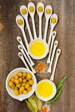 Pattern of ceramic spoons with olives and spices. Stock Photos