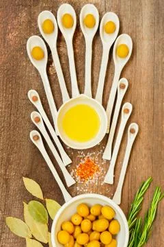 Pattern of ceramic spoons with olives and spices. Stock Photos