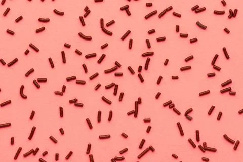 Pattern of chocolate sprinkles over trendy color living coral background, dec Foto stock