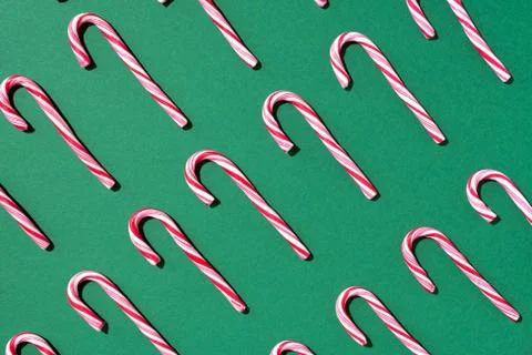 Pattern of Christmas candy cane on green background. Top view. Flat lay Stock Photos